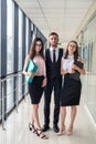 Dream team of three professional business people who discussing paperwork in modern office hallway Royalty Free Stock Photo