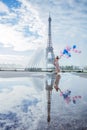 Dream travel - young woman with balloons walking near Eiffel Tower in Paris