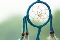 Dreamcatcher close-up on a background of green grass and blue sky. Blurred background