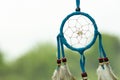 Dreamcatcher close-up on a background of green grass and blue sky. Blurred background.