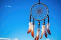 dreamcatcher hanging against a bright sky backdrop