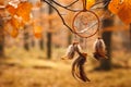 Dreamcatcher hanging on branch in autumn forest