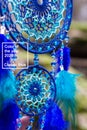 Dreamcatcher made of feathers, leather, beads, and ropes in classic blue trendy Color of the year 2020