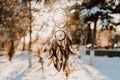 Dreamcatcher, spiritual protection amulet with feathers on sunset background.