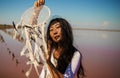 Dreamcatcher at sunset , asian girl boho chic with ethnic amulet at pink sea. symbol peace and harmony.