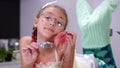 Dreamful girl with mermaid tail combs pink hair in kitchen