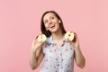 Dreamful pretty young woman in summer clothes looking up holding halfs of fresh ripe apple fruit isolated on pink pastel