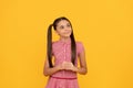 Dreamful school age girl child with pensive look fantasize about something yellow background, dreamer Royalty Free Stock Photo