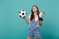 Dreamful woman football fan cheer up support favorite team with soccer ball, Earth world globe isolated on blue