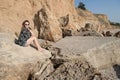 Dreaming beautiful girl sitting on big stones. Royalty Free Stock Photo