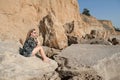 Dreaming beautiful girl sitting on big stones. Royalty Free Stock Photo