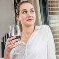 Dreaming beautiful young woman enjoying holding wine glass for degustation Royalty Free Stock Photo