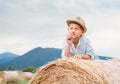 Dreaming boy lying on the rolling haystack Royalty Free Stock Photo