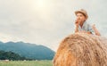 Dreaming boy in straw hat lies on roll haystack Royalty Free Stock Photo