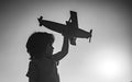 Dreaming boy with wooden plane. Kid boy playing with toy airplane at sunset. Child dreams of traveling and playing with Royalty Free Stock Photo