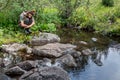 Dreaming girl sitting on bridge with forest and river on the background. Lonely sad woman by the lake. Beautiful woman Royalty Free Stock Photo