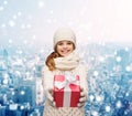 Dreaming girl in winter clothes with gift box Royalty Free Stock Photo
