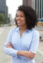 Dreaming hispanic woman in the city with crossed arms Royalty Free Stock Photo