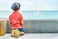 Dreaming little boy with panama looks at yacht sailing sea Royalty Free Stock Photo