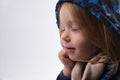 Dreaming little girl dressed for winter hold hands under chin head isolated