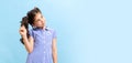 Portrait of winsome little girl,school age kid in summer dress isolated over blue background. Concept of children Royalty Free Stock Photo