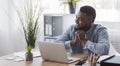 Portrait of pensive black employee sitting at workplace in office