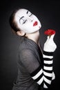 Dreaming woman mime with red flower