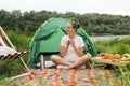 Dreaming woman relaxing near the river, enjoying coffee or tea, admiring beautiful nature, spending summertime near the lake, Royalty Free Stock Photo