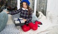 Dreams come true. Kid at home relaxing on cozy window sill. Magic moment. Happy winter holidays. Small girl opening gift Royalty Free Stock Photo