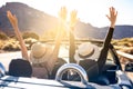Dreams come true! Two happy young girls driving cabrio car during vacation road trip in mountains, making memories and having fun Royalty Free Stock Photo