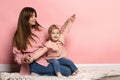 Dreams. Portrait of young woman and little girl, mother and daughter isolated on pink studio background. Mother& x27;s