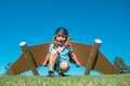 Dreams of travel. Child flying on jetpack with toy airplane on sky background. Happy child boy playing in cardboard Royalty Free Stock Photo