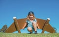 Dreams of travel. Child flying on jetpack with toy airplane on sky background. Happy child boy playing in cardboard Royalty Free Stock Photo