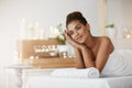 Dreamy beautiful girl in towel resting in spa salon. Royalty Free Stock Photo