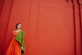 Dreamy beautiful young girl in red dress and green jacket. Royalty Free Stock Photo