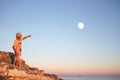 Dreamy boy points his finger with the moon in the sky