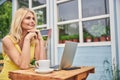 Dreamy Caucasian blonde middle-aged woman sitting outdoors Royalty Free Stock Photo