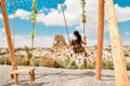 Dreamy caucasian girl on famous Cappadocia swings enjoy sunny day in Ortahisar