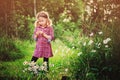 Dreamy child girl in plaid dress on the walk in summer day with bouquet of chamomile flowers Royalty Free Stock Photo