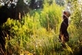 Dreamy child girl on summer walk on riverside. Cozy rural scene. Outdoor activities Royalty Free Stock Photo