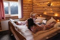 Teen friends in same Christmas pajamas relaxing in bed inside cozy log cabin with winter view Royalty Free Stock Photo