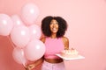 Dreamy curly haired brunette woman celebrates special date, makes a wish and looks up, poses with helium balloons and Royalty Free Stock Photo
