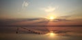 Dreamy and dramatic colorful sunset sky over water surface with cloud reflections