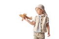 Explorer boy in glasses and hat holding wooden toy plane isolated on white