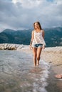 Dreamy fashion girl walk on beach with mountains background Royalty Free Stock Photo