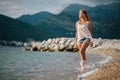 Dreamy fashion girl walk on beach with mountains background Royalty Free Stock Photo