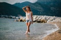 Dreamy fashion girl walk on beach with mountains background Royalty Free Stock Photo