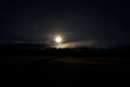 Dreamy full moon night sky over field, forest road and mountain Royalty Free Stock Photo