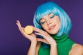 Dreamy girl in blue wig posing with macaron isolated