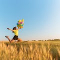 Dreamy girl jumping high with bunch of balloons Royalty Free Stock Photo